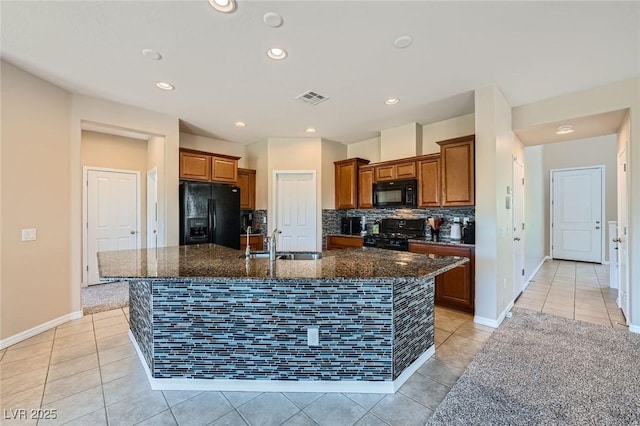 kitchen with visible vents, brown cabinets, a sink, black appliances, and light tile patterned flooring