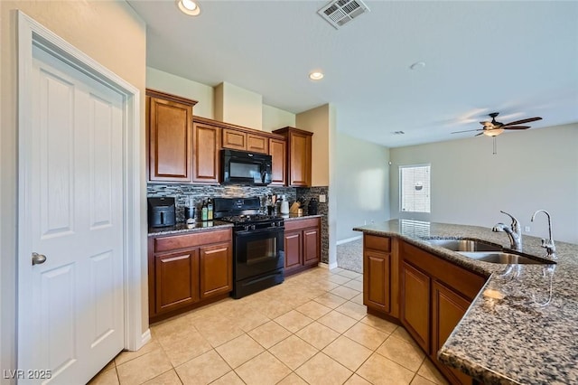 kitchen with visible vents, tasteful backsplash, a sink, light tile patterned floors, and black appliances