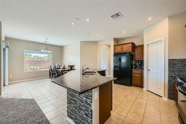 kitchen with visible vents, light tile patterned floors, a sink, backsplash, and black appliances
