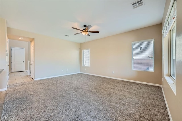 spare room with visible vents, baseboards, ceiling fan, and light colored carpet