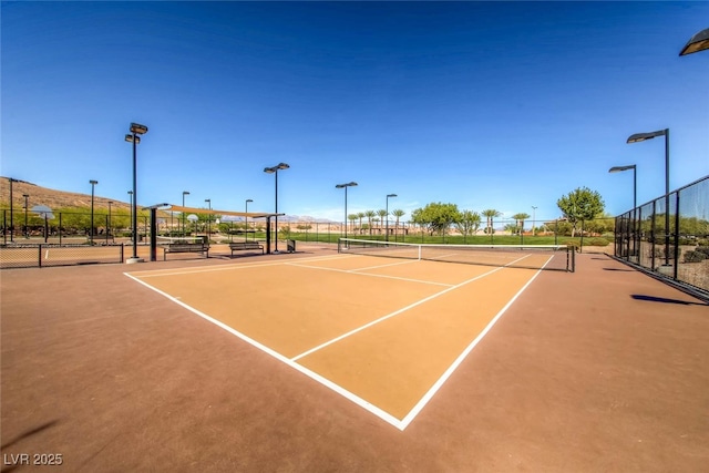 view of tennis court featuring fence and community basketball court