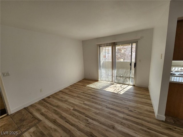 unfurnished room featuring baseboards and wood finished floors