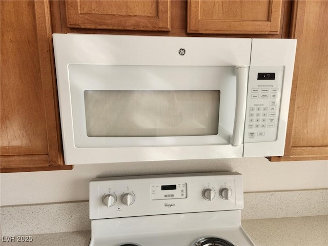 details featuring light countertops, brown cabinetry, stove, and white microwave