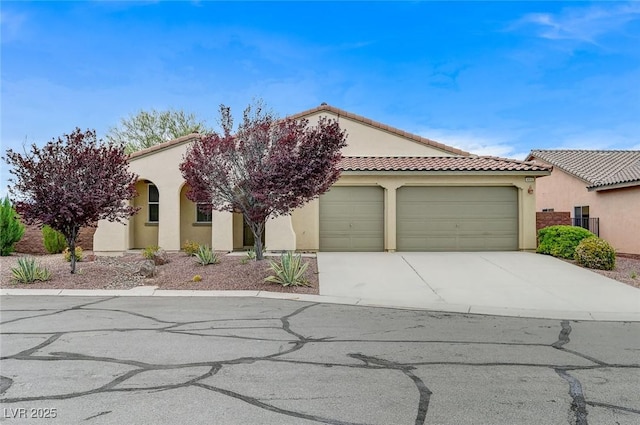 view of front of property with concrete driveway, stucco siding, an attached garage, and a tiled roof