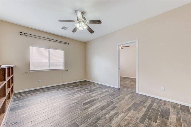 unfurnished room featuring visible vents, a ceiling fan, baseboards, and wood finished floors