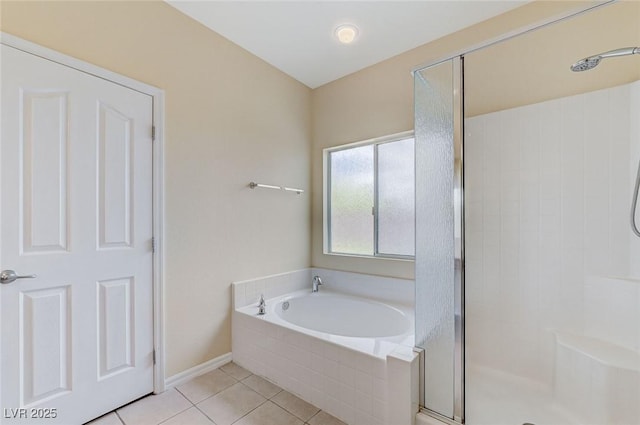 bathroom with tile patterned floors, a shower stall, baseboards, and a garden tub