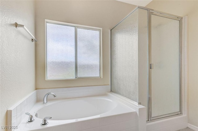 full bath featuring plenty of natural light, a stall shower, and a garden tub