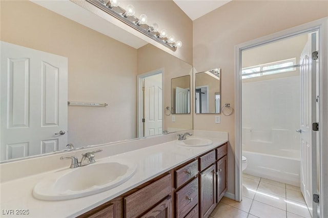full bath featuring a sink, tile patterned floors, toilet, and double vanity