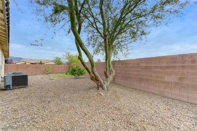 view of yard featuring a fenced backyard and central AC