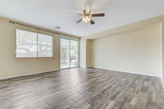 spare room with a ceiling fan, baseboards, visible vents, and wood finished floors