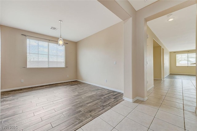 spare room with visible vents, baseboards, and light wood-type flooring
