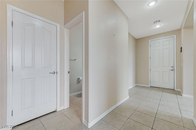 hall featuring light tile patterned floors, baseboards, recessed lighting, and visible vents