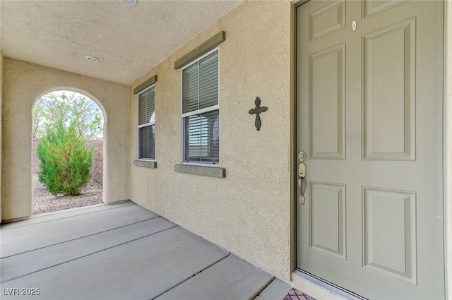 property entrance featuring a patio and stucco siding