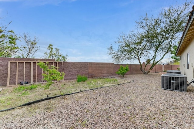 view of yard featuring central AC and a fenced backyard