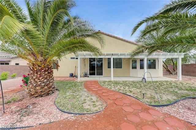 back of house featuring a pergola, fence, a patio area, and stucco siding