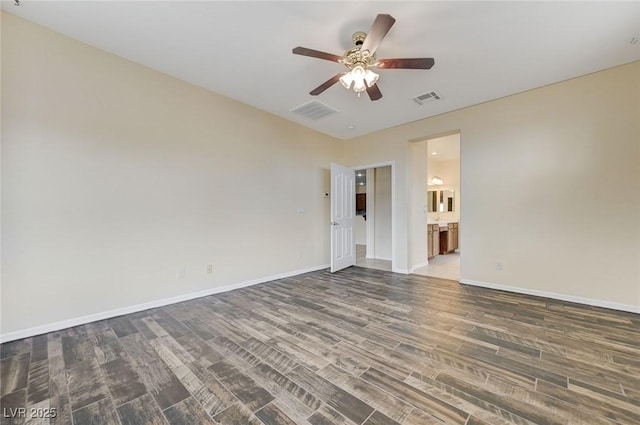 spare room featuring visible vents, baseboards, ceiling fan, and wood finished floors