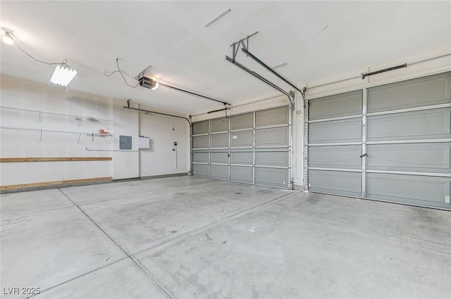 garage with a garage door opener and electric panel