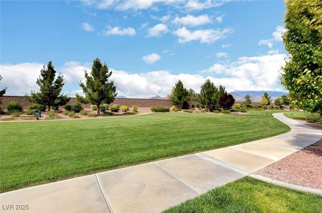 surrounding community with a lawn and a mountain view