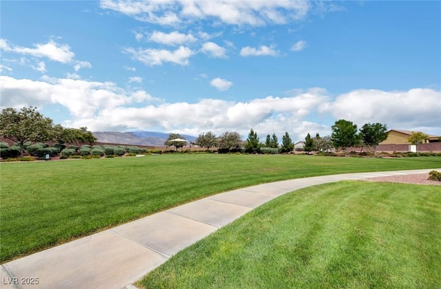 view of community with a lawn and a mountain view