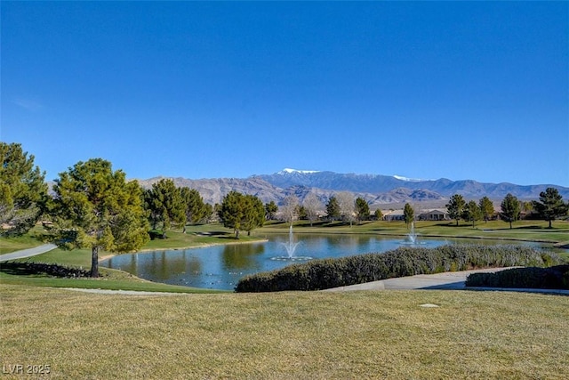 view of community with a lawn and a water and mountain view
