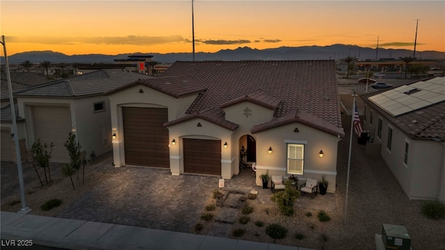 6325 Gambetta St, Las Vegas, NV 89115 - mediterranean / spanish-style home with a garage, decorative driveway, stucco siding, a mountain view, and a tile roof