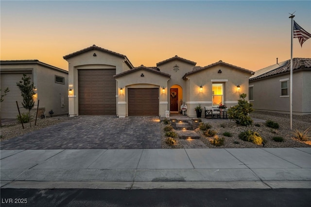 6325 Gambetta St, Las Vegas, NV 89115 - mediterranean / spanish house featuring decorative driveway, a garage, stucco siding, and a tiled roof