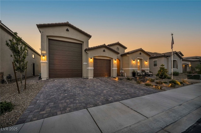 6325 Gambetta St, Las Vegas, NV 89115 - mediterranean / spanish house with a garage, stucco siding, a tiled roof, and decorative driveway