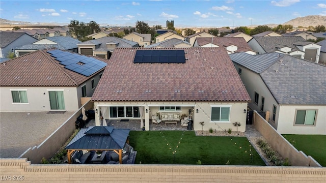 6325 Gambetta St, Las Vegas, NV 89115 - back of house featuring solar panels, a residential view, a patio area, a fenced backyard, and stucco siding