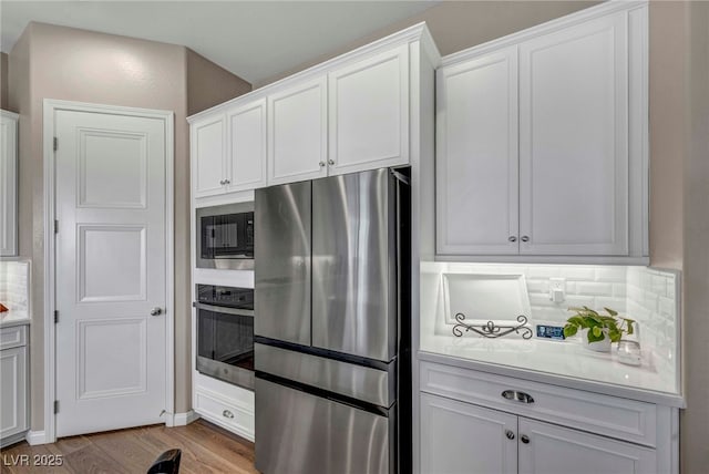 6325 Gambetta St, Las Vegas, NV 89115 - kitchen with light countertops, white cabinets, stainless steel appliances, and light wood-type flooring