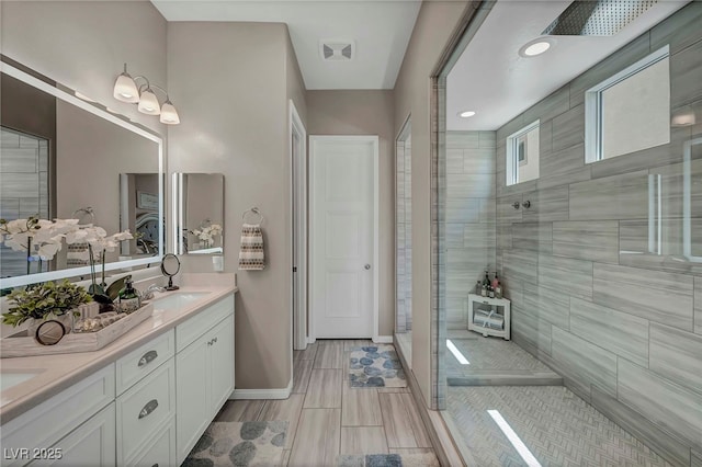 6325 Gambetta St, Las Vegas, NV 89115 - bathroom featuring double vanity, baseboards, a tile shower, and visible vents