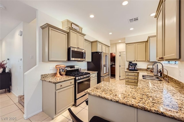 8091 Mosaic Sunrise Ln, Las Vegas, NV 89166 - kitchen featuring appliances with stainless steel finishes, light stone counters, a peninsula, light tile patterned flooring, and recessed lighting