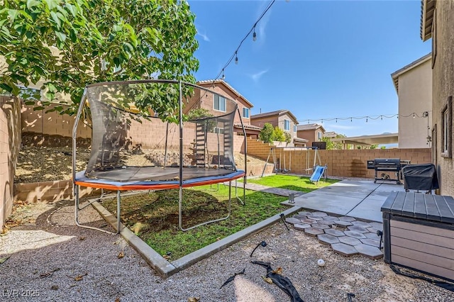 8091 Mosaic Sunrise Ln, Las Vegas, NV 89166 - fenced backyard featuring a trampoline and a patio area