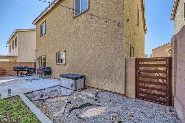8091 Mosaic Sunrise Ln, Las Vegas, NV 89166 - view of property exterior with stucco siding, a gate, and a patio area