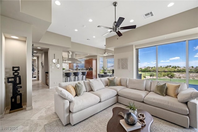 living area with a wealth of natural light, a ceiling fan, recessed lighting, and visible vents