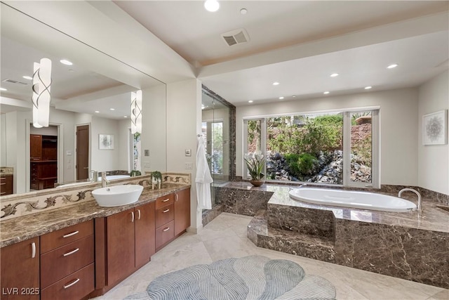 full bath featuring a garden tub, recessed lighting, visible vents, and vanity