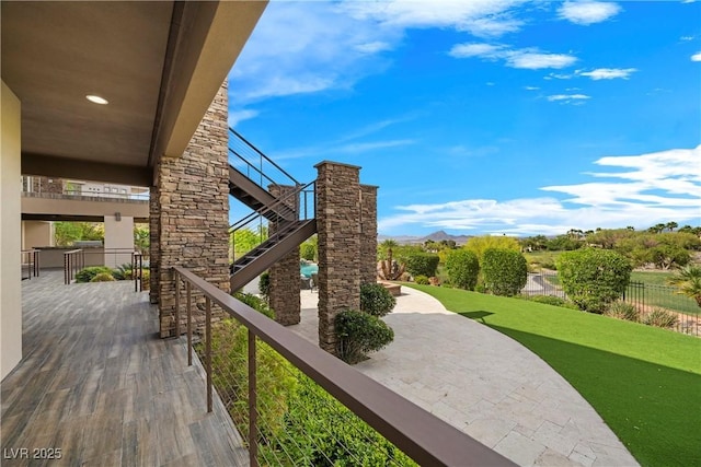 view of home's community featuring fence, a yard, and stairway