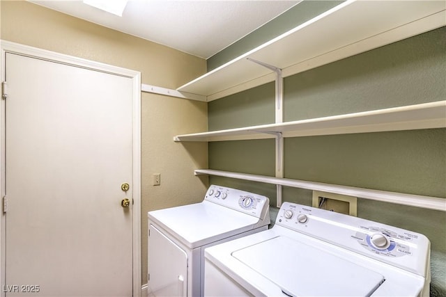 laundry area featuring a textured wall, laundry area, and washing machine and dryer