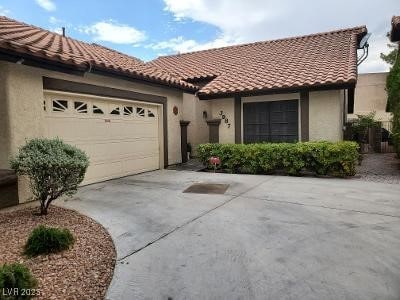 mediterranean / spanish home with concrete driveway, an attached garage, a tile roof, and stucco siding