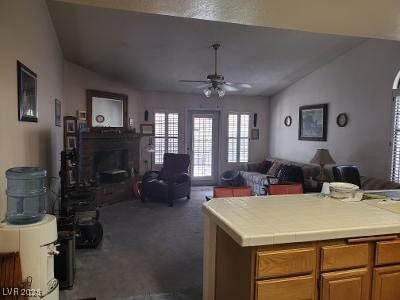 living area with dark carpet, ceiling fan, vaulted ceiling, and a fireplace