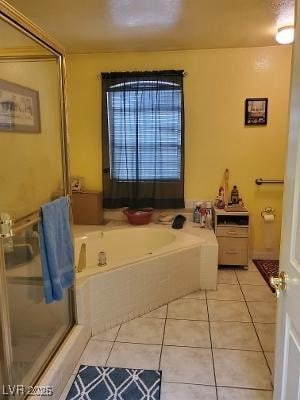 bathroom with tile patterned flooring, a shower with shower door, and a bath