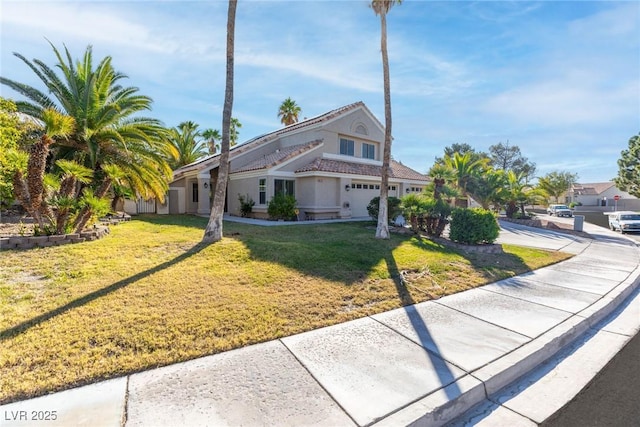 view of front of house featuring concrete driveway, a front yard, and stucco siding