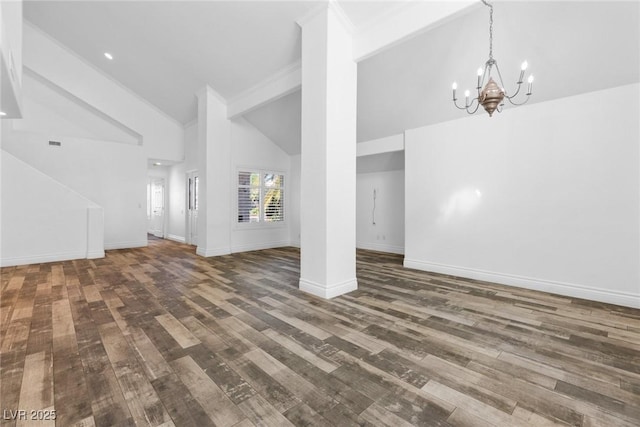 unfurnished living room with crown molding, baseboards, high vaulted ceiling, dark wood-style floors, and an inviting chandelier