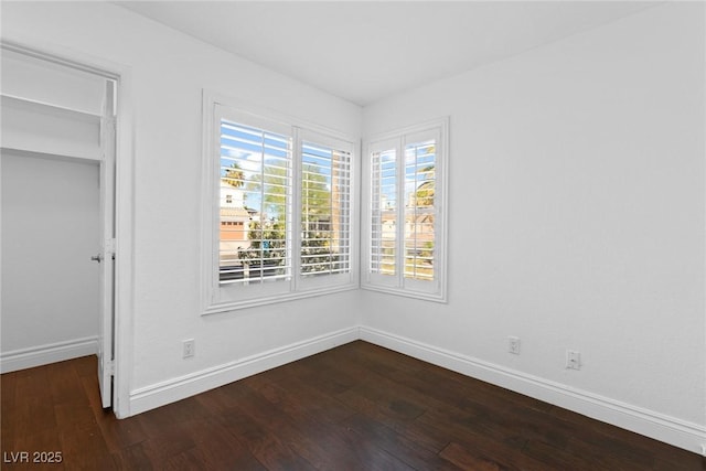 empty room featuring baseboards and hardwood / wood-style flooring