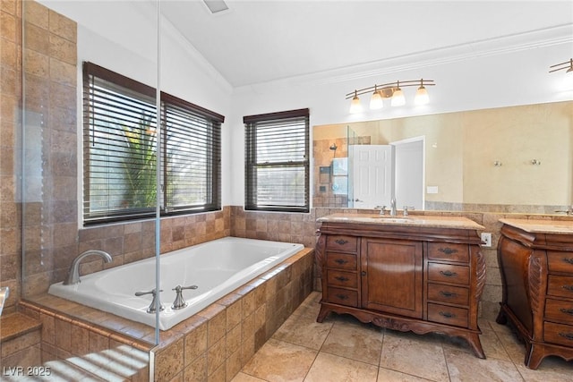 bathroom with crown molding, tile patterned floors, tile walls, two vanities, and a bath