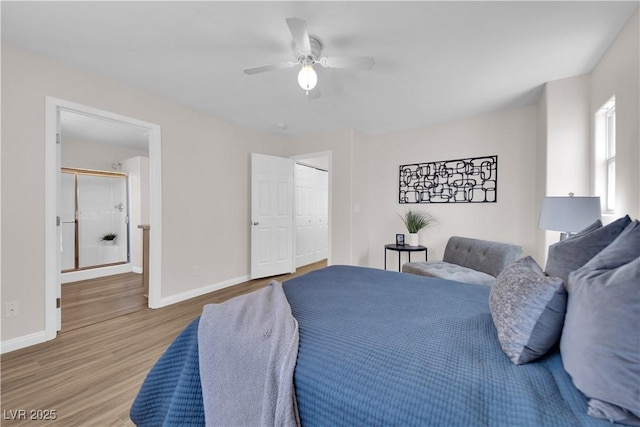 bedroom with baseboards, a ceiling fan, ensuite bath, and wood finished floors