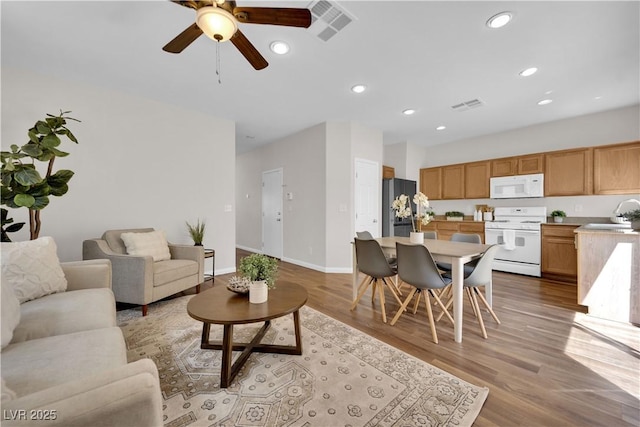 living area with light wood-style floors, a ceiling fan, recessed lighting, and visible vents
