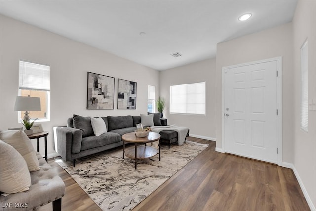 living area featuring plenty of natural light, baseboards, and visible vents