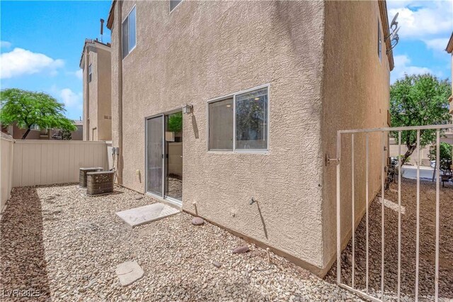 view of side of property with fence and stucco siding