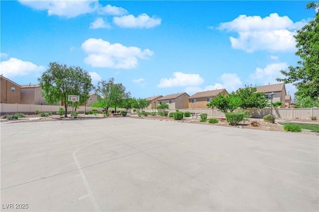 view of basketball court featuring fence, community basketball court, and a residential view