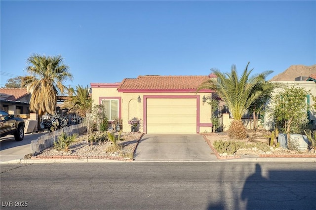view of front of house featuring stucco siding, a tiled roof, concrete driveway, and a garage